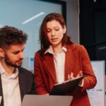 ISO/IEC 42001 Lead Implementer vs Lead Auditor: two professionals reviewing a checklist